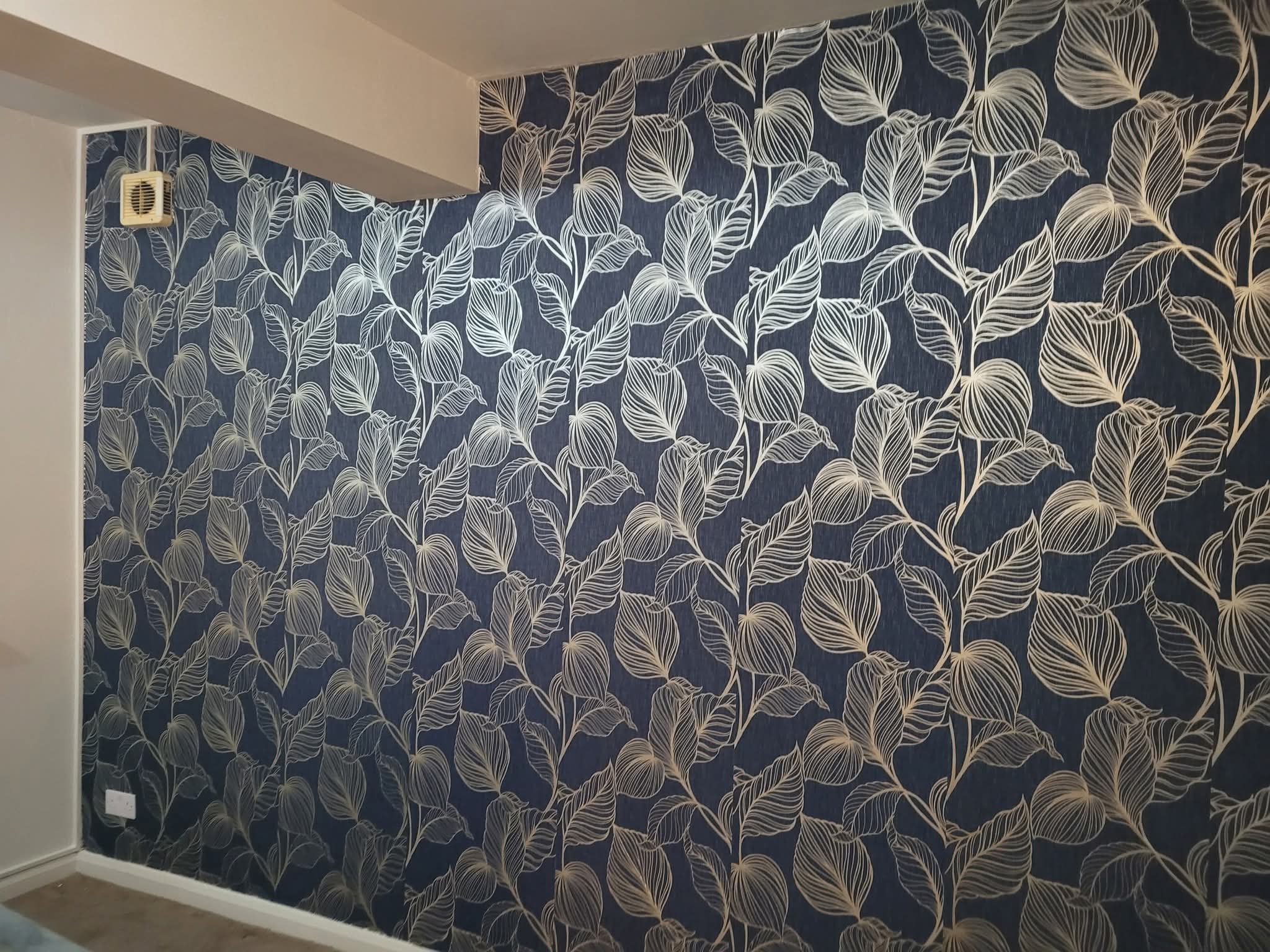 Haya UK gallery photograph of blue and gold botanical wallpaper above clean white skirting.
